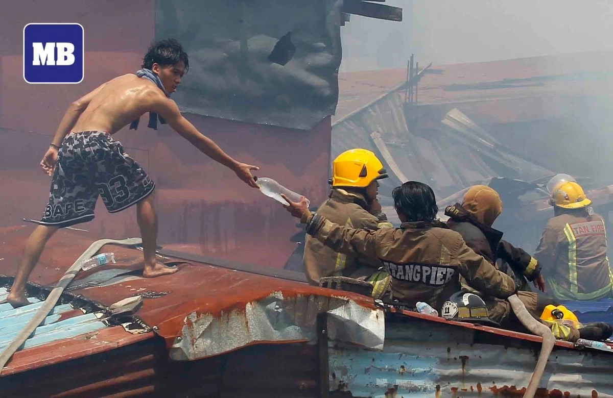 Firefighters train their hoses on a residential area engulfed in flames in the Gasangan, Baseco Port Area, Manila on Saturday, May 30. The blaze reached the third alarm. (Photo taken by Mark Balmores/Manila Bulletin)