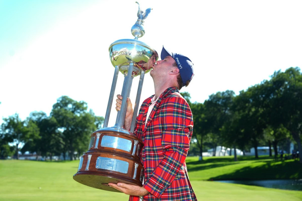 Russell Henley kisses the winner's trophy after the final round of the Charles Schwab Challenge golf tournament at Colonial Country Club in Fort Worth, Texas, Sunday, May 31, 2026. (AP Photo/LM Otero)