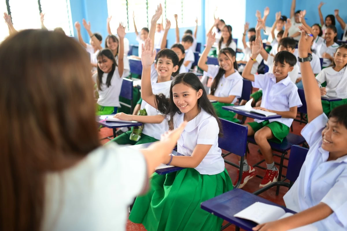 An enthusiastic classroom of active participants eager to raise their hands and excel at Booy South Elementary School in Bohol.

