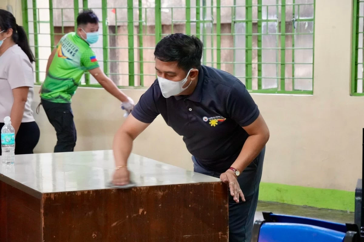 A volunteer dusted off old desks and windows inside classrooms. (OVP photo) 
