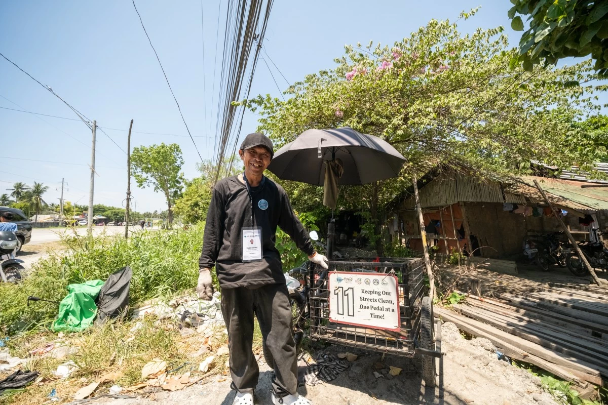 Elmer Rodrigo, a waste worker under Project E-REDUCE, stands beside his padyak used for daily collection across barangays in General Santos City, supporting more organized and safer waste management.