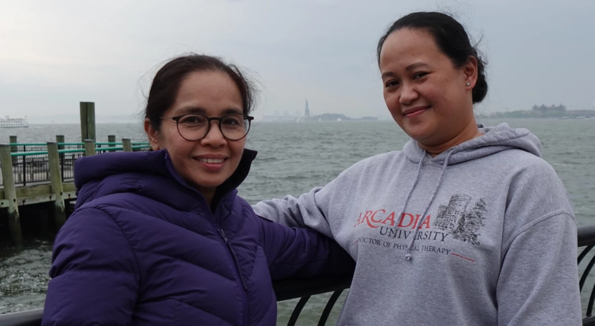 Richie Carrido (L) with Alyssa Tumulak, PT, DPT, Grandison's professional development services head (R) at Battery Park, with the Statue of Liberty in the background.
