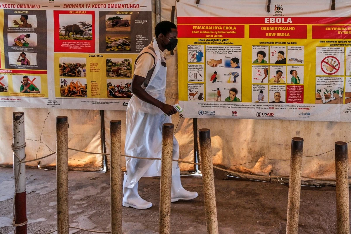 A health worker walks past Ebola warning and instruction posters at a temporary health clinic at the Mpondwe border crossing linking Uganda and the Democratic Republic of the Congo, Thursday, June 4, 2026. (AP Photo/Hajarah Nalwadda)