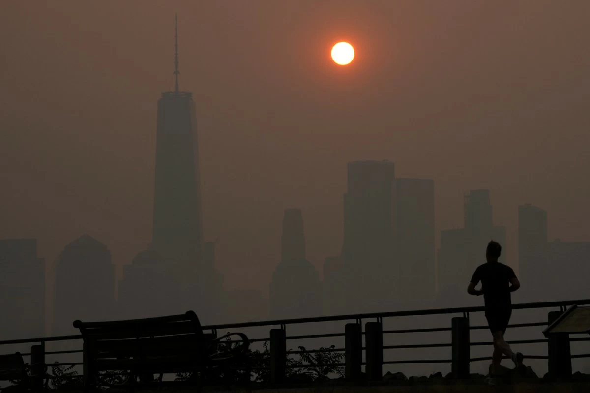 A man runs in front of the sun rising over the lower Manhattan skyline in Jersey City, N.J., June 8, 2023. (AP Photo/Seth Wenig, File)