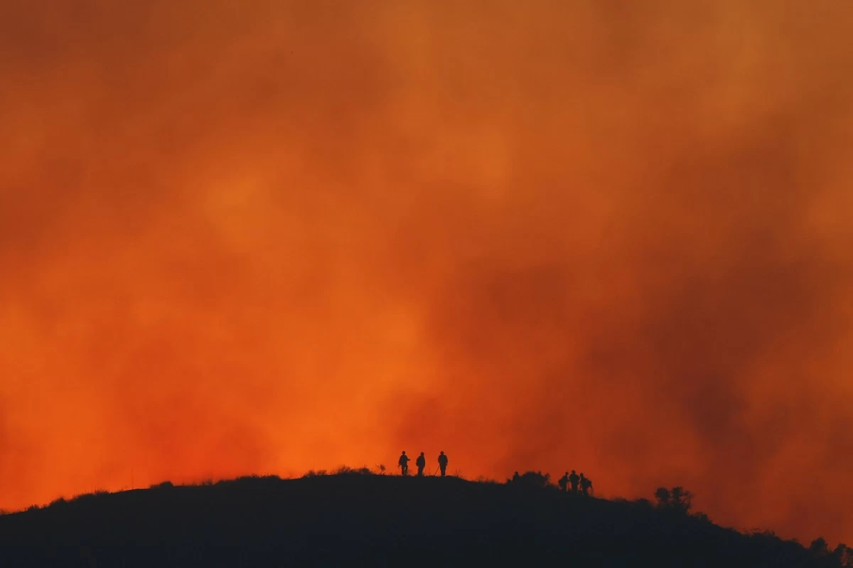 Firefighters are silhouetted amid an operation to control the Sandy Fire, May 19, 2026, in Simi Valley, Calif. (AP Photo/Caroline Brehman, File)