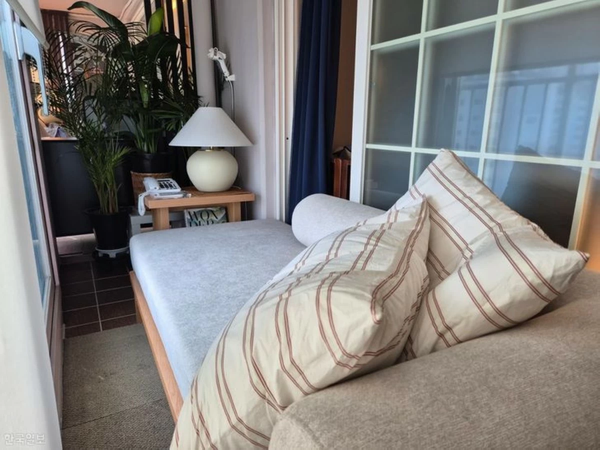 Yoon Ji-in styles her bedroom balcony with a long sofa, cushions and a table. The unplugged telephone serves as a prop to complete the hotel aesthetic. (Photo: The Korea Times/Kim Na-yeon)