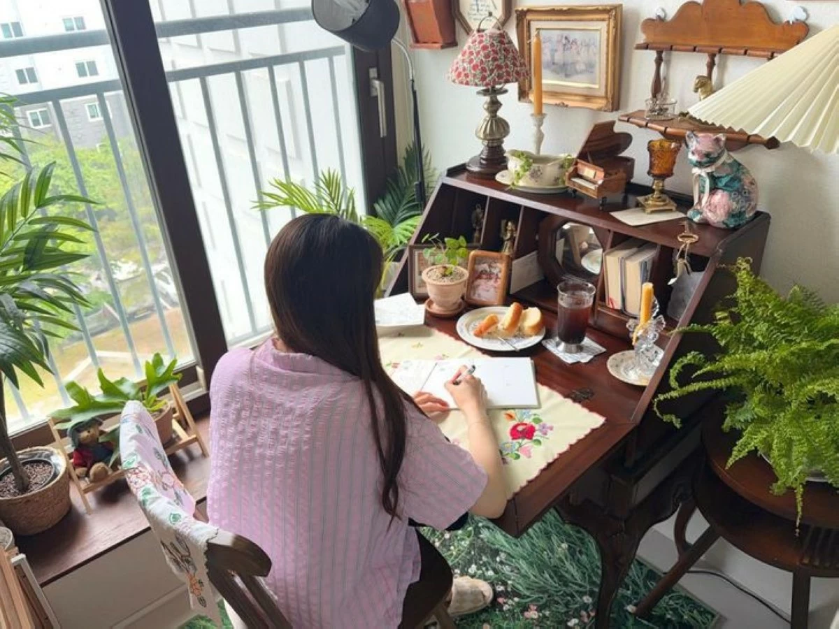 Oh Jung-won writes in her journal on her bedroom balcony. She calls the space, decorated with her favorite vintage items, her personal hideout. (Photo: The Korea Times/Oh Jung-won)