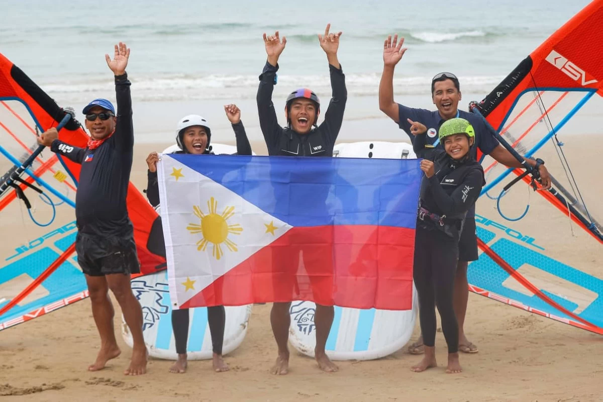 GERMAN PAZ (extreme left) celebrates the victory of windsurfer Dhenver Castillo (center) in the 6th Asian Beach Games. 