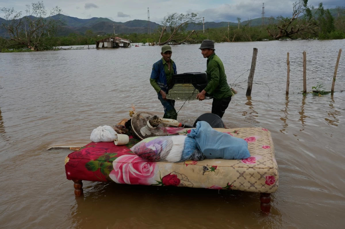 People recover belongings from a home flooded by Hurricane Melissa in Santiago de Cuba, Oct. 29, 2025. (AP Photo/Ramón Espinosa, File)