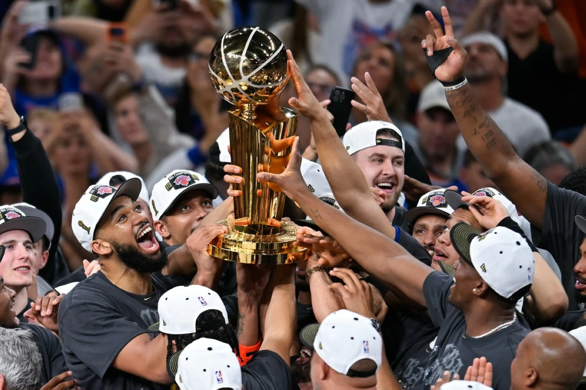 The New York Knicks celebrate with the Larry O'Brien Championship Trophy after defeating the San Antonio Spurs in Game 5 of the NBA Finals basketball series, Saturday, June 13, 2026, in San Antonio. (AP Photo/Darren Abate)