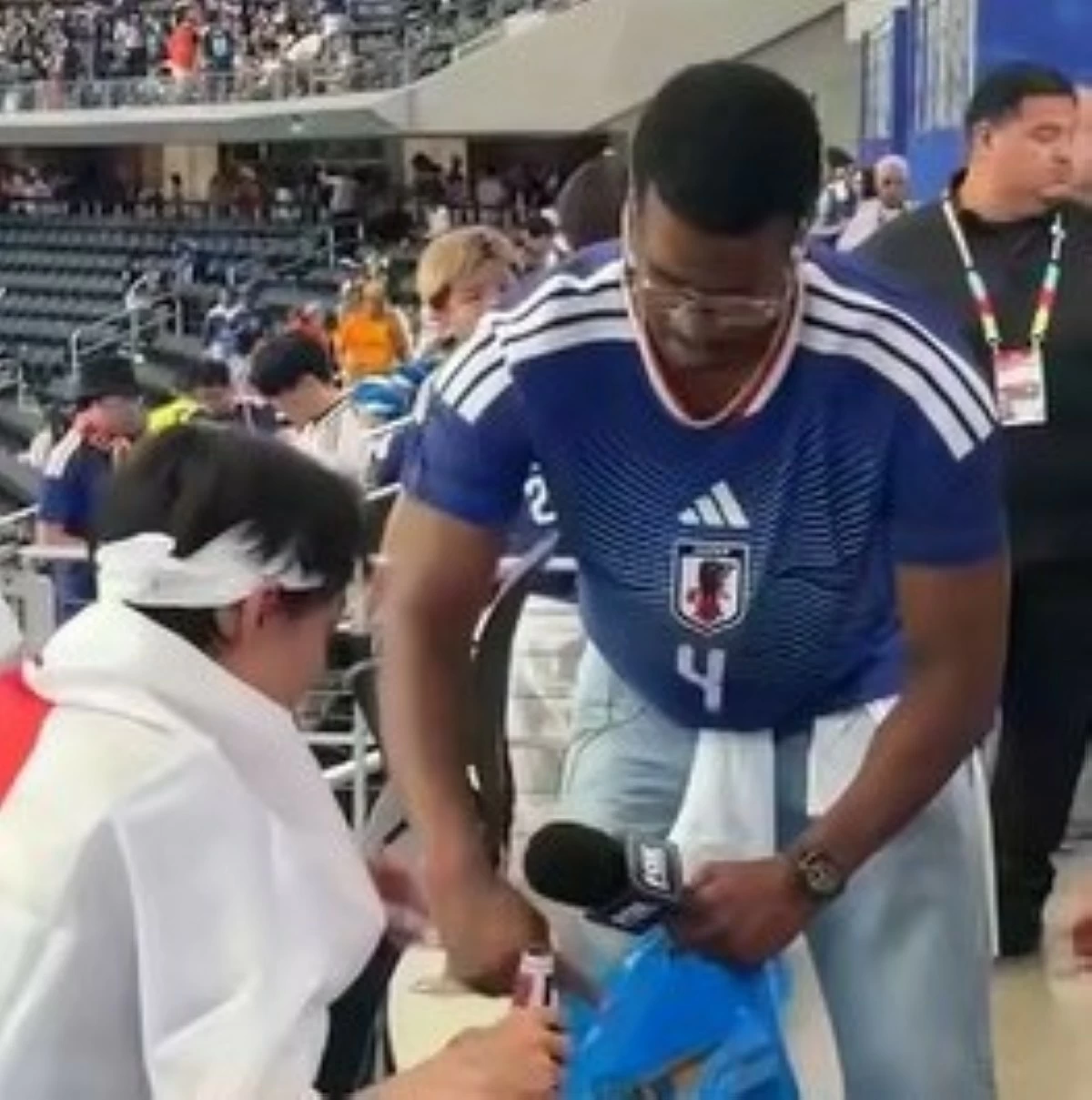 Jameis Winston (front right), a quarterback for the New York Giants of the U.S. National Football League, picks up trash with Japanese supporters after the World Cup match against the Netherlands near Dallas on Sunday. (From FOX's official site)