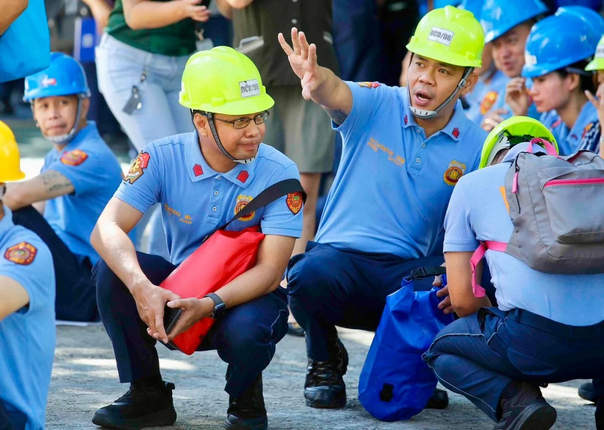 Personnel of the Manila Police District carry out evacuation and headcount procedures during the nationwide earthquake drill at their headquarters in Manila.