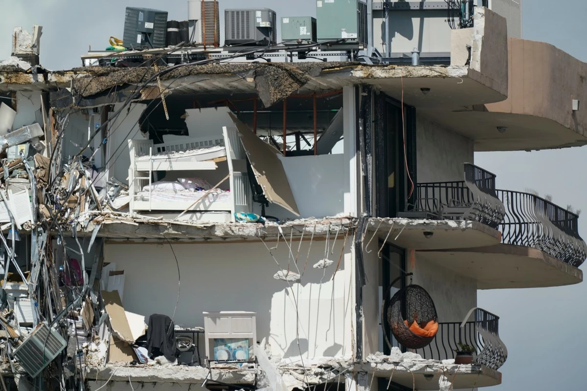 FILE - Furniture sits perched in the remains of apartments sheared in half in the still standing portion of the Champlain Towers South condo building, July 2, 2021, in Surfside, Fla. (AP Photo/Mark Humphrey, File)