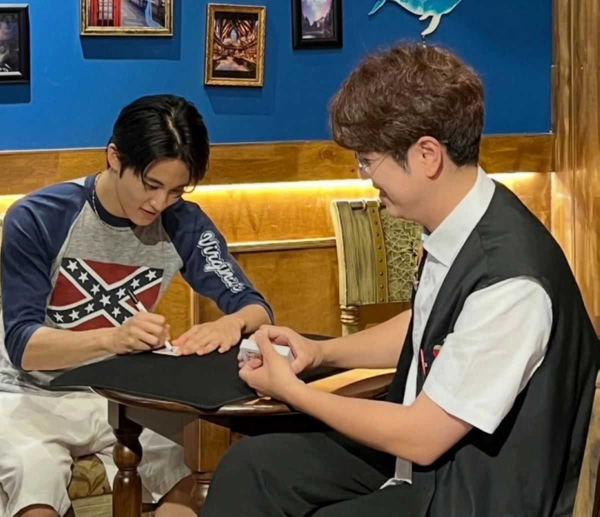 Former NCT member Mark (left) wearing the shirt with the Confederate flag (Photo from online community) 