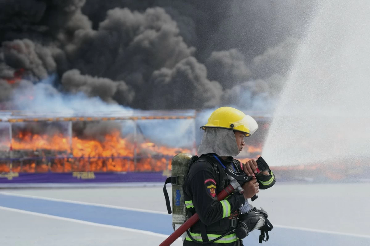 Firefighters spray water in front of illegal narcotics being burnt during a destruction ceremony marking the U.N.’s International Day Against Drug Abuse and Illicit Trafficking, on the outskirts of Yangon, Myanmar, Friday, June 26, 2026. (AP Photo/Thein Zaw)
