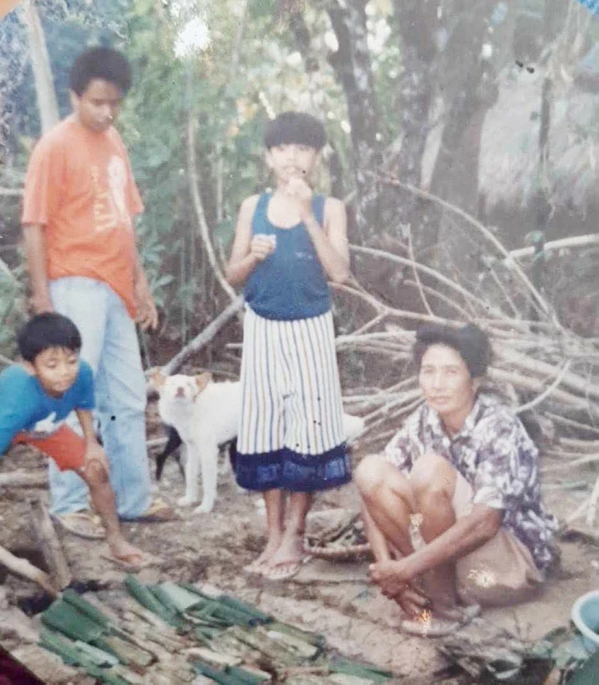 Maulit (left), his uncle Rodel, and cousin Rodelinson Jr. watch his lola Trining make tupig.