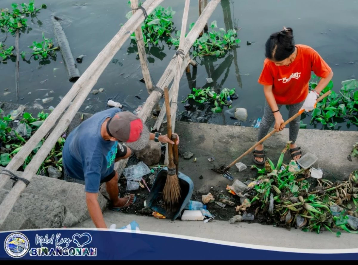 Two residents remove waste from Laguna Lake during a recent clean-up drive in Binangonan, Rizal (Photo from Mahal Kong Binangonan).