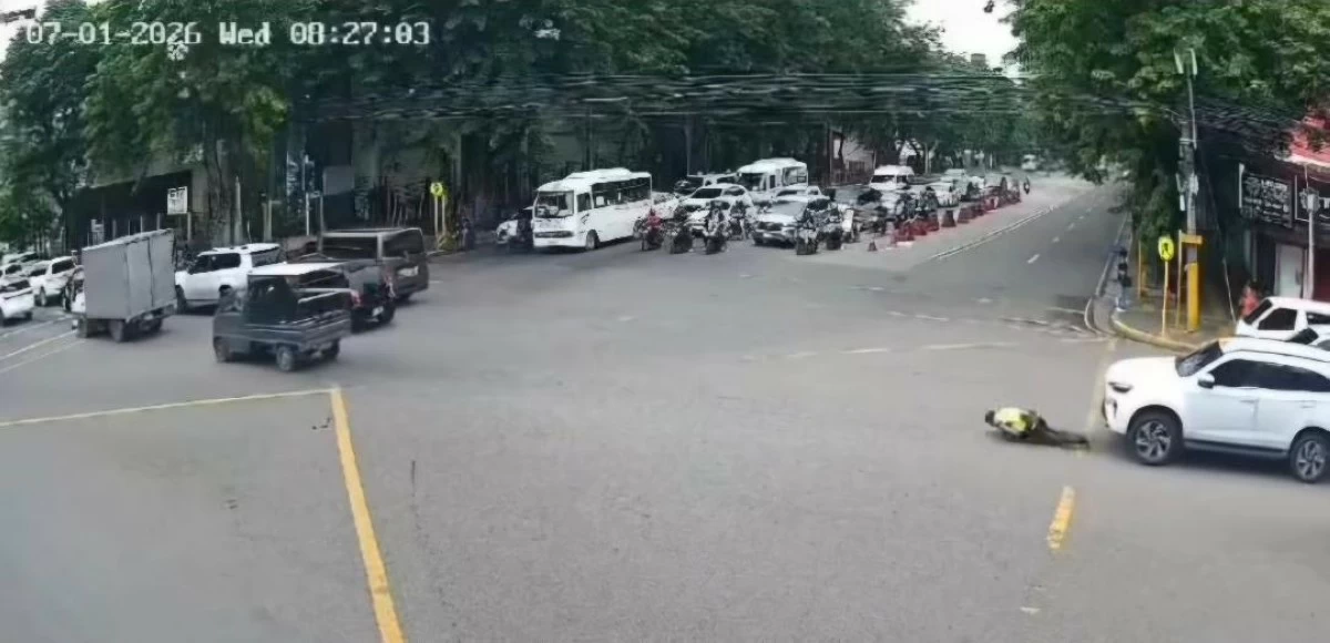 A TRAFFIC enforcer falls to the ground after he was hit by an SUV in the middle of the road in Cebu City. (Screengrab)