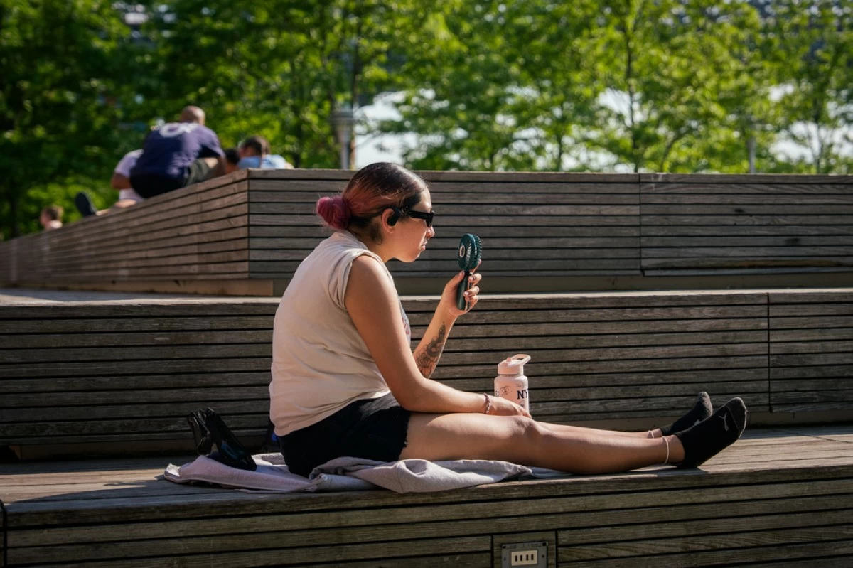 FILE - A person uses an electric fan during a heat advisory, in the Brooklyn borough of New York, May 19, 2026. (AP Photo/Adam Gray, File)