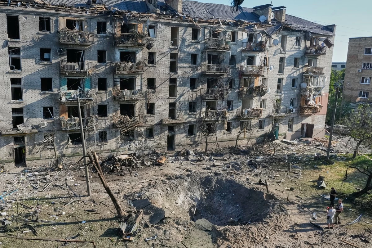 People look at the site of a Russian missile strike that hit a residential building in Kyiv, Ukraine, Thursday, July 2, 2026. (AP Photo/Efrem Lukatsky)