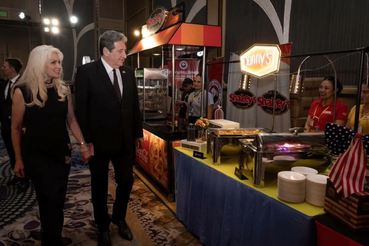 Fast food, soft power. US’ top envoy in the Philippines inspects the menu at the national day reception. (Photo: US Embassy)
