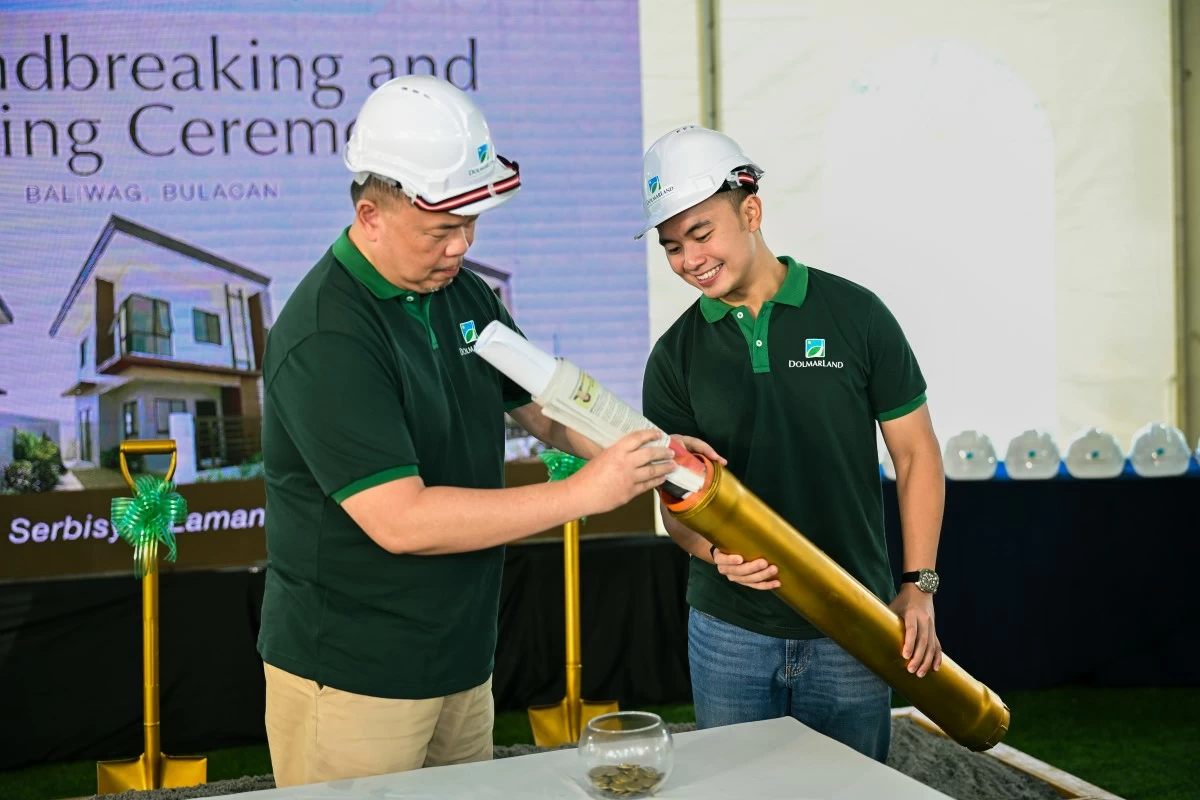 John Tan Jr., chairman of the board and president and Francis Tan, director of Operations, prepare the time capsule at the Legacia launch event. (Photo: Dolmar Land)