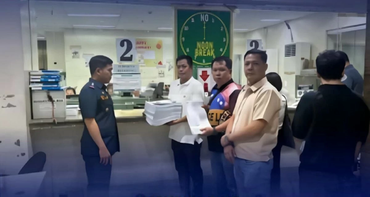 Officials hold documents related to the murder complaints filed before the Quezon City Prosecutor’s Office against suspects in the ambush slay of a businessman and his driver. (Photo courtesy of QCPD)