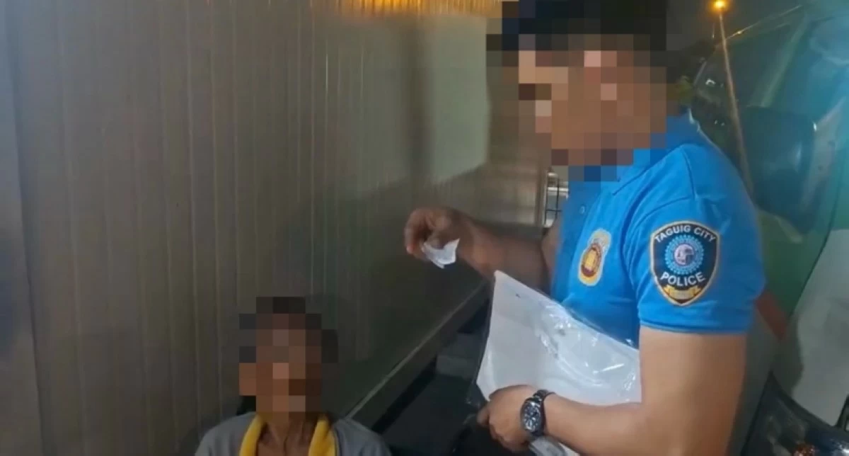 A Taguig police officer (right) with the suspect (Photo from Taguig police/SPD)