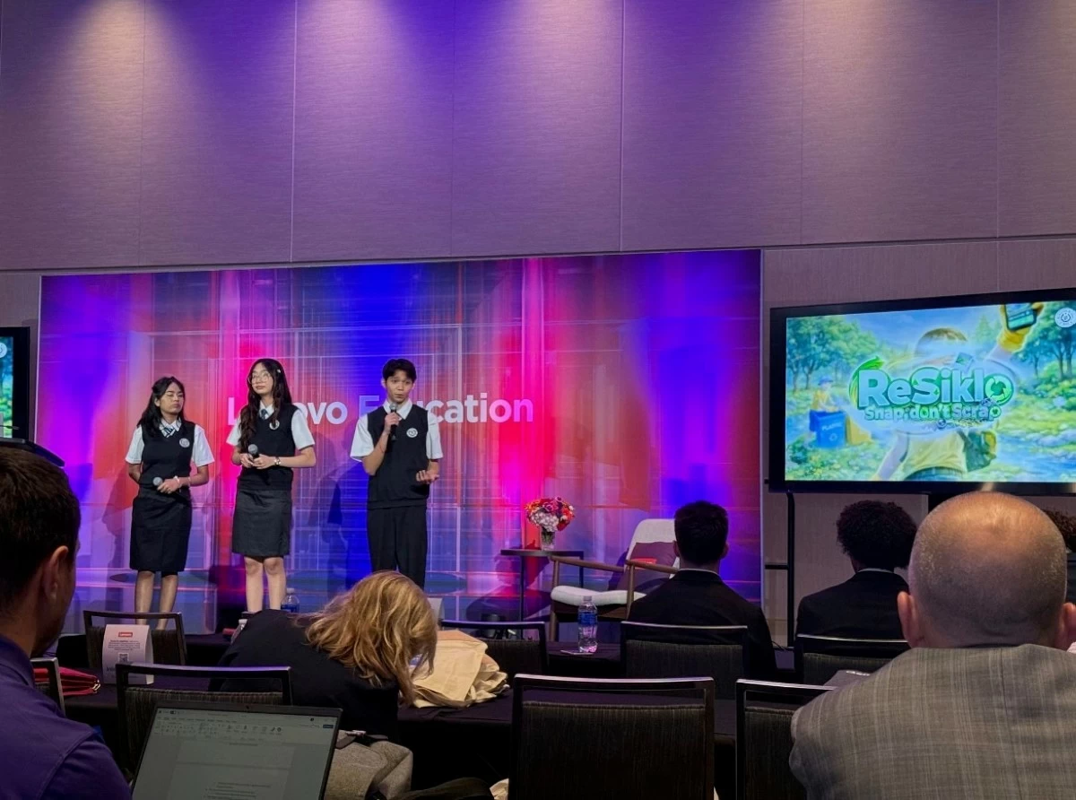 Viktoria Binuya, Alexandra Manungay, and Jo Justin Ong present their AI-powered innovation 'ReSiklo' during the SparkTalk session on the Lenovo stage.