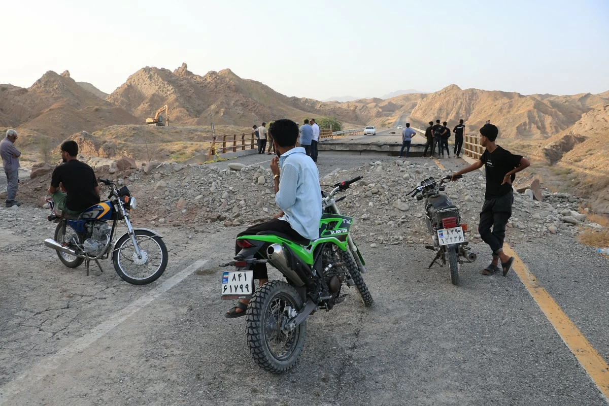 People stand on a bridge destroyed after a strike in Hormozgan province, southern Iran, Saturday, July 18, 2026. (Amirhosein Khorgooi/Iranian Students' News Agency via AP)