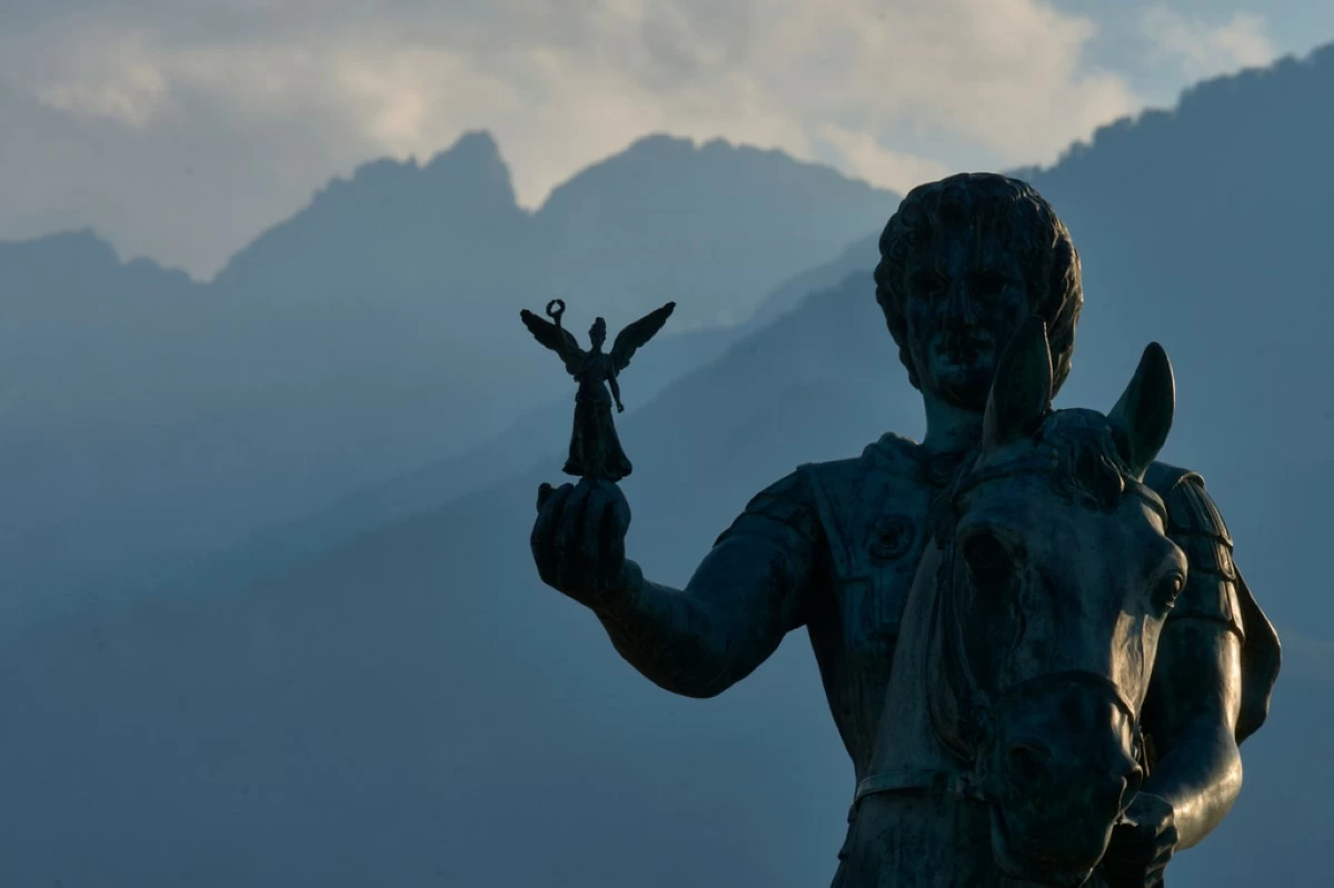 A statue of Alexander the Great holding Nike, the Greek goddess of victory, stands near Litochoro in northern Greece, Tuesday, July 14, 2026, backdropped by Mount Olympus' highest peaks, Mytikas and Stefani. (AP Photo/Petros Giannakouris)