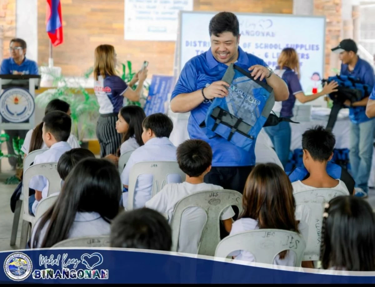 Vice Mayor /Russel Ynares distributes bags to elementary students (Photo from Binangonan Action Center Volunteer Group's FB page)
