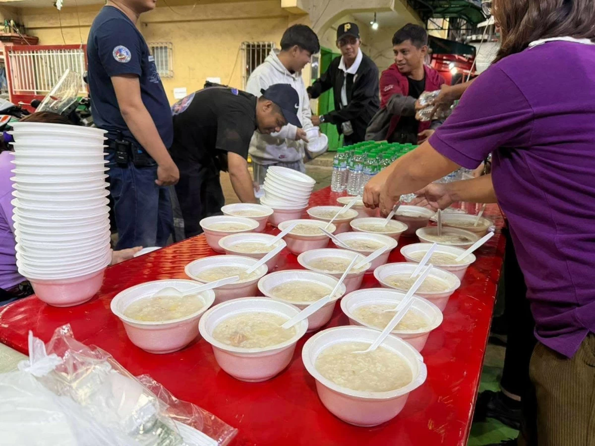 MDSW personnel distribute hot meals to families displaced by the third-alarm fire at Dagupan Extension, Tondo, Manila. (Photo courtesy of MDSW)