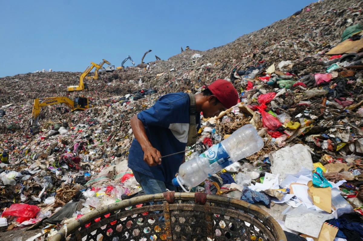 Komaruddin, a waste picker, looks for recyclable items in a pile of garbage at the Bantargebang landfill on the outskirts of Jakarta, Indonesia, Monday, July 6, 2026. (AP Photo/Tatan Syuflana)