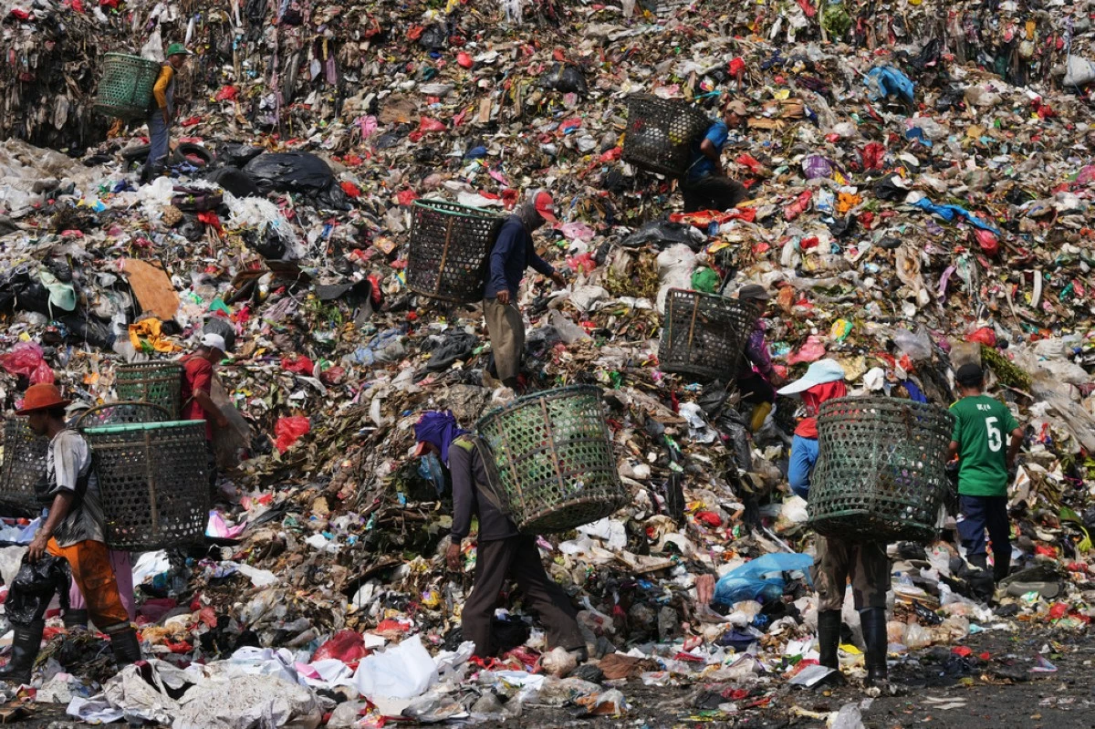 Waste pickers look for recyclable items in a pile of garbage at the Bantargebang landfill on the outskirts of Jakarta, Indonesia, Monday, July 6, 2026. (AP Photo/Tatan Syuflana)