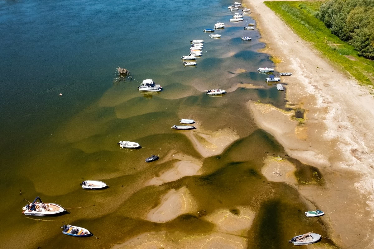Boats sit on a bank of the Danube River where usually submerged areas are exposed due to extremely low water levels following an extended period of drought in Islaz, Romania, Wednesday, July 29, 2026. (AP Photo/Nicolae Dumitrache)