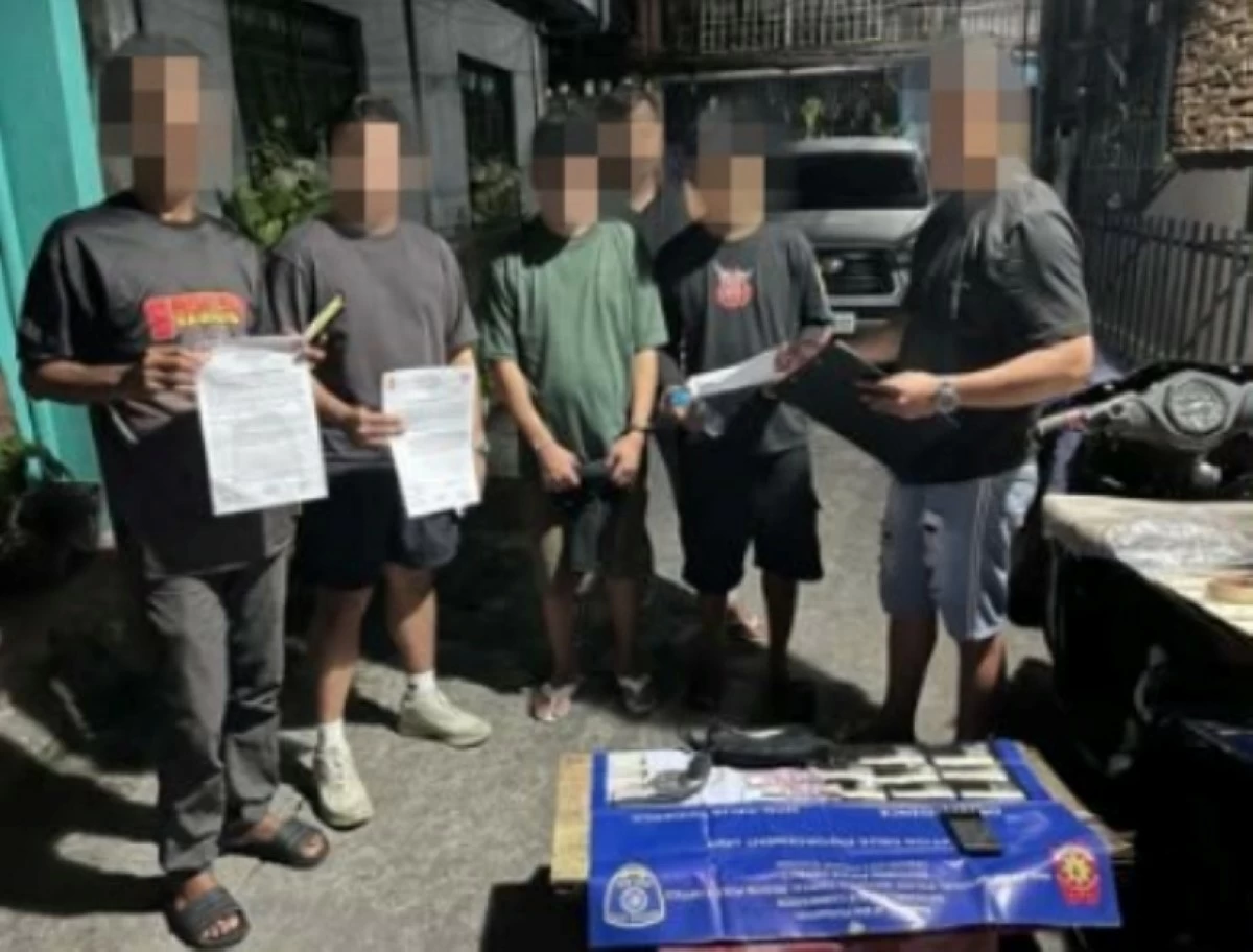 A Taguig police officer interrogates two drug suspects arrested on July 31. (Photo from Taguig police/SPD)