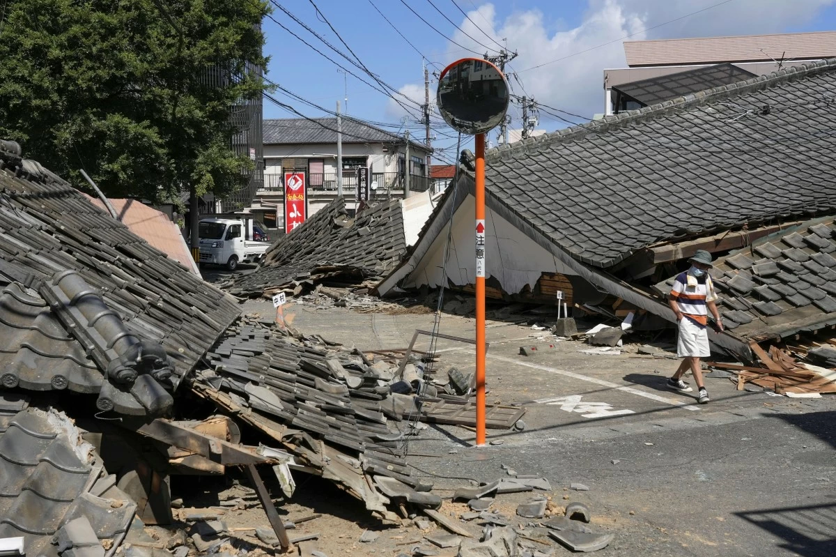 A PERSON walks past houses that collapsed in an earthquake in Yatsushiro, Kumamoto Prefecture, southern Japan, Friday, July 31, 2026. (Koji Harada/Kyodo News via AP)