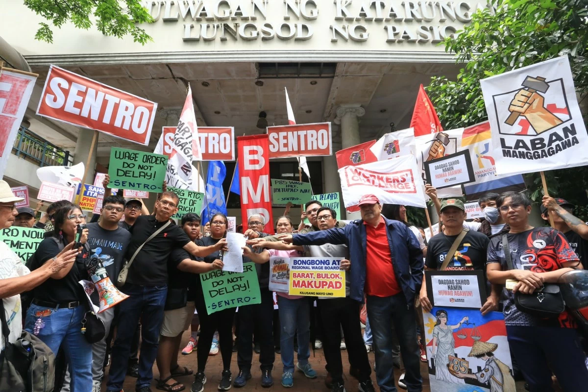 Labor groups and workers’ coalitions protest outside the Pasig Regional Trial Court on Monday, Aug. 3, condemning the temporary restraining order that suspended the ₱85 minimum wage hike in Metro Manila. (Santi San Juan)