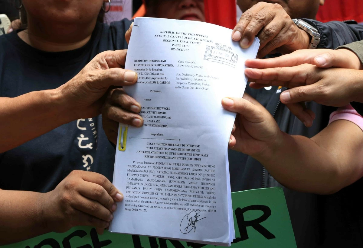 Labor groups and workers’ coalitions protest outside the Pasig Regional Trial Court on Monday, Aug. 3, condemning the temporary restraining order that suspended the ₱85 minimum wage hike in Metro Manila. (Santi San Juan)