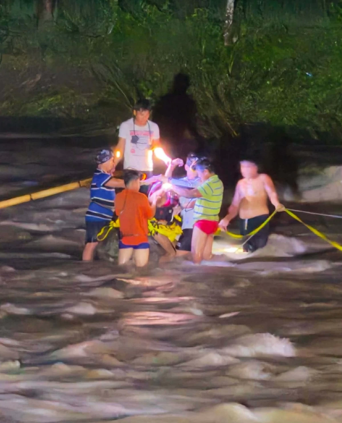 Personnel of the MDRRMO and PDRRMO rescue two individuals  stranded by strong river current in Barangay Lower Tumapoc, Burgos, La Union on Monday night. They were reportedly trying to retrieve their cattle when they were caught by rising waters.(Photo via Liezle Basa-Inigo)