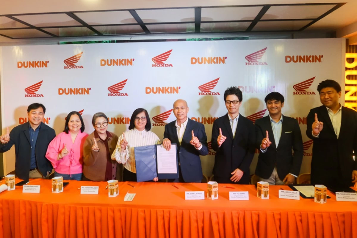 Honda and Golden Donuts executives sign the contract signifying their partnership.