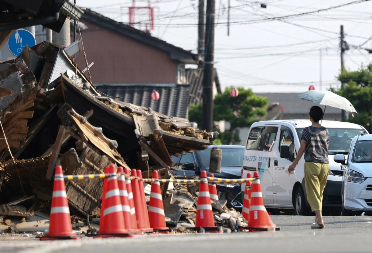 A person walks with a parasol under intense heat in a disaster-hit area of Hikawa, Kumamoto Prefecture, on Tuesday, August 4, 2026.