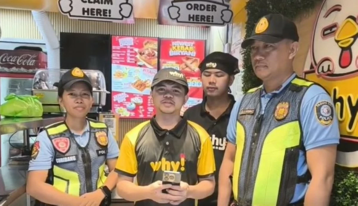Taguig police officers with the owner of the cell phone (Photo from Taguig police / SPD)  