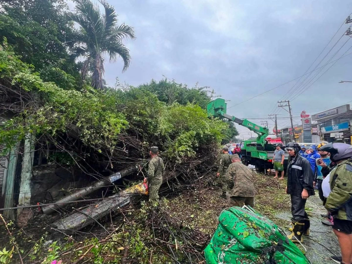 A delivery rider taking shelter along Circumferential Road in Barangay San Roque, Antipolo, was rushed to RPHS Antipolo Annex 2 for medical attention after being struck by a falling tree and post on Sunday, Aug. 9. (Photos from Mayor Jun Ynares/Facebook)