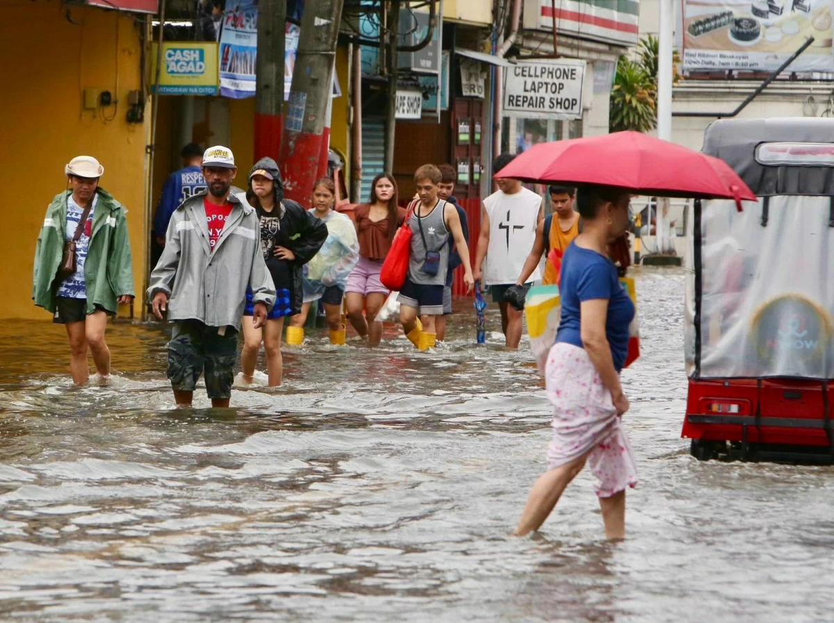 People walk through floodwaters along a street in Binakayan, Kawit, Cavite, on Sunday, August 9, 2026, as heavy rains continue to affect the area. Residents and other people heading to local markets navigate the flooded streets to buy essential supplies. (Contributed Photos)