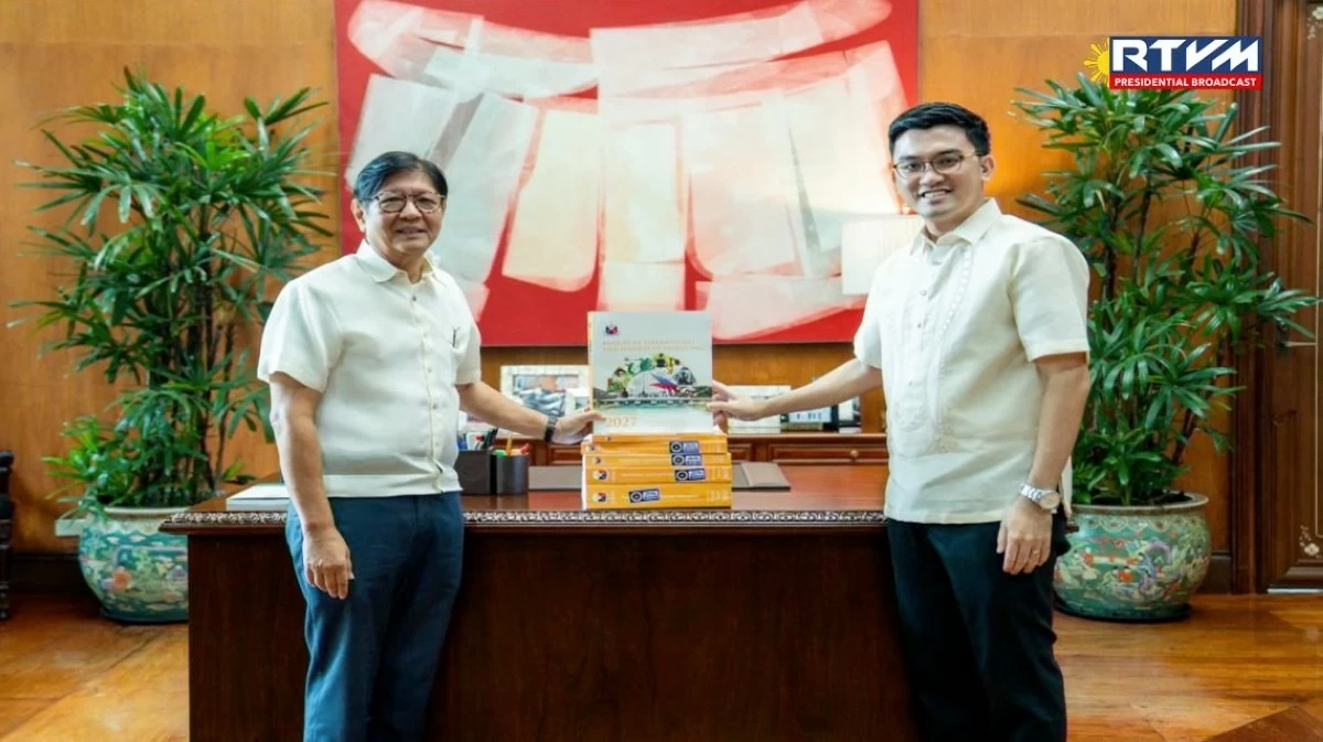 President Ferdinand 'Bongbong' Marcos receives a copy of the proposed P7.2-trillion 2027 National Expenditure Program from Department of Budget and Management Secretary Kim de Leon during the formal submission of the budget proposal at Malacañan on Aug. 10, 2026. (RTVM)