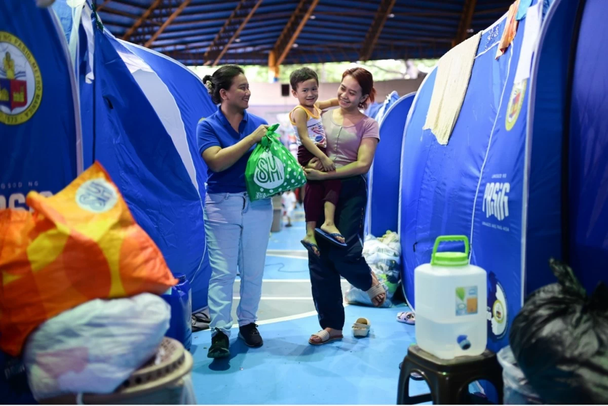  
PASIG CITY, Philippines. SM Foundation volunteer hands over a Kalinga Pack to a resident affected by the recent fire incident in Brgy. Kapitolyo, Pasig City through the Operation Tulong Express program.
