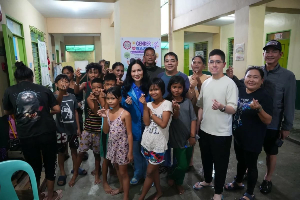 Mayor Jeannie Sandoval poses with evacuees and city personnel during a visit to an evacuation center in Malabon. (Photo from Malabon LGU)