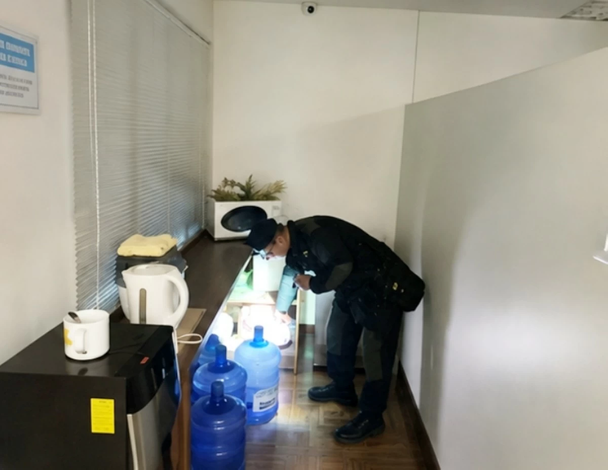 A Muntinlupa police officer inspects an area in an office in Barangay Ayala Alabang, Muntinlupa following a bomb threat on Aug. 10 (Photo from Muntinlupa police / SPD)